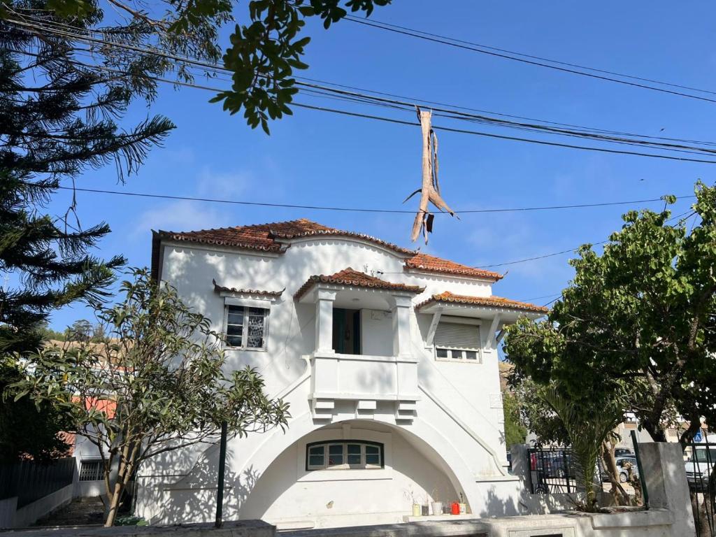 a white building with a red roof at Come Inn Costa da Caparica in Costa da Caparica