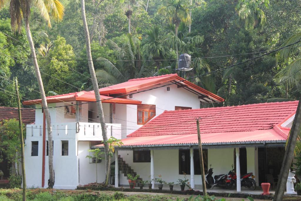 ein weißes Haus mit einem roten Dach in der Unterkunft Sandaru Holiday Resort in Weligama