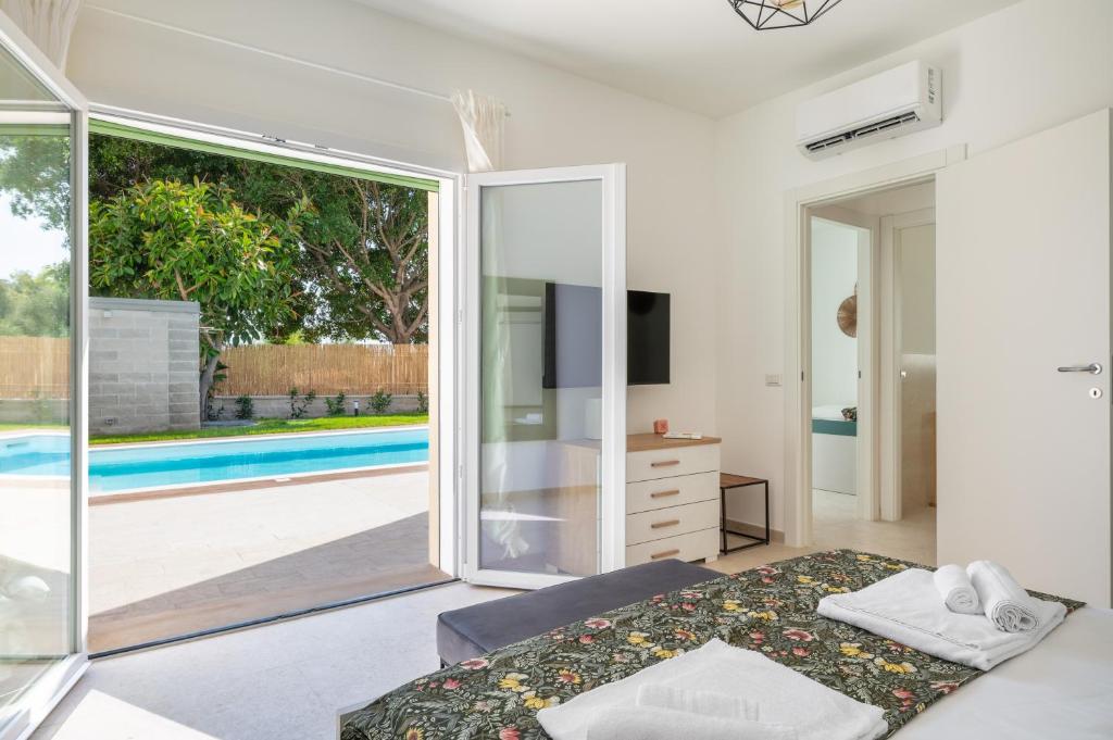 une chambre avec vue sur une piscine dans l'établissement Villa Medusa, à Brucoli