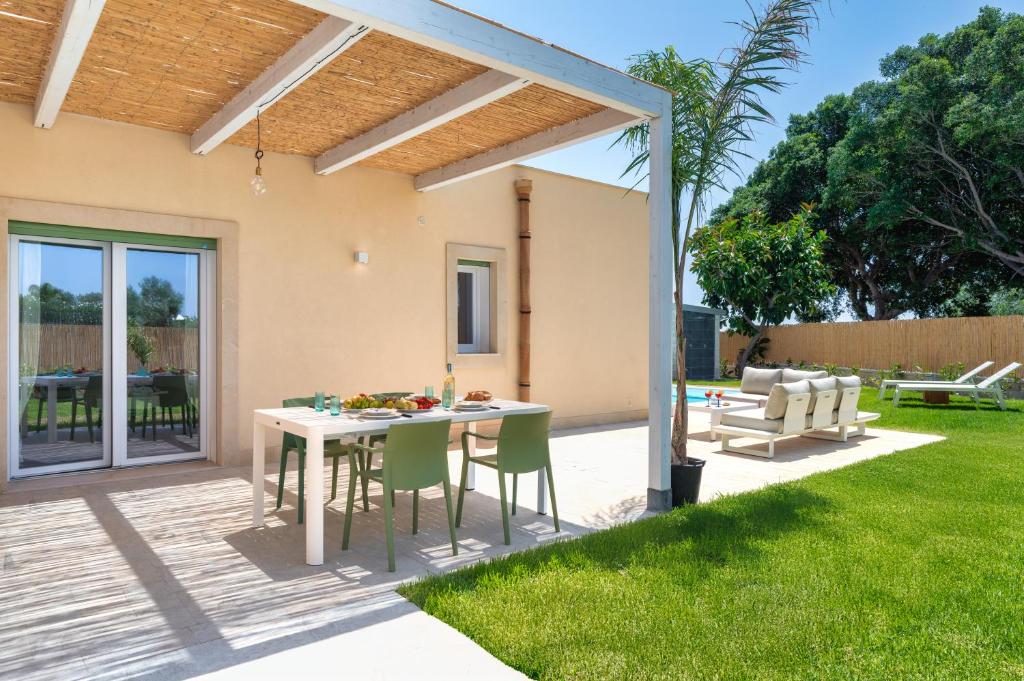 un patio avec une table et des chaises dans une cour dans l'établissement Villa Medusa, à Brucoli