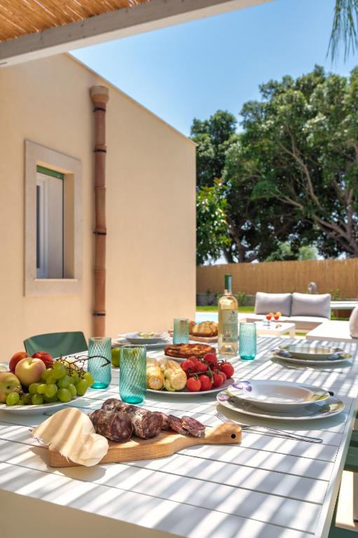 une table avec des assiettes de nourriture dessus dans l'établissement Villa Medusa, à Brucoli