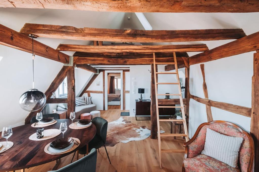 a living room with a wooden table and chairs at Das Alte Pfarrhaus Galerie in Gleisweiler