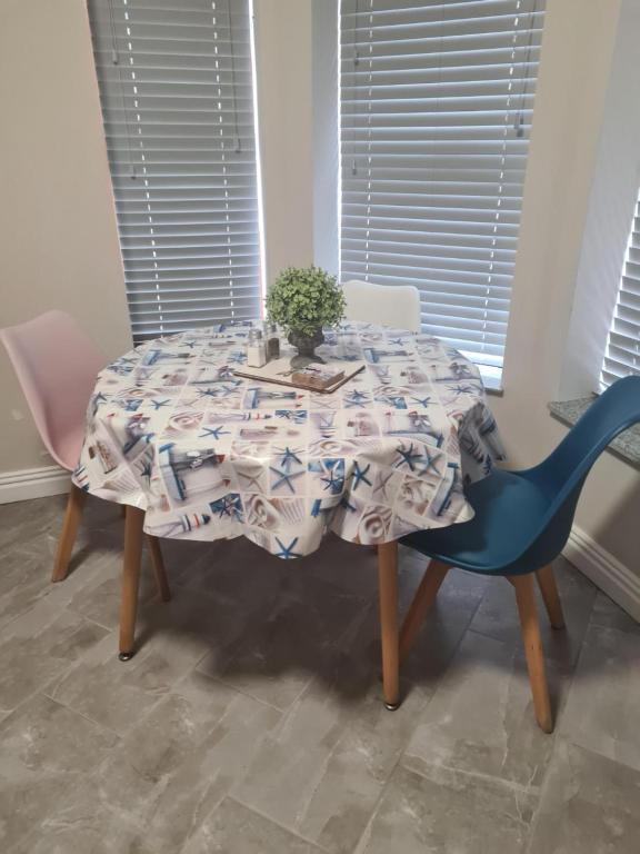 a table with a blue chair and a table cloth on it at One Bedroom Manse Ave Apartment in Portrush