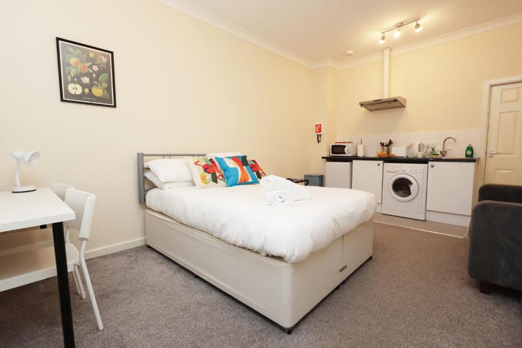 a bedroom with a bed and a washing machine at Chic Bath Flat for Couples with Free Parking! in Bath
