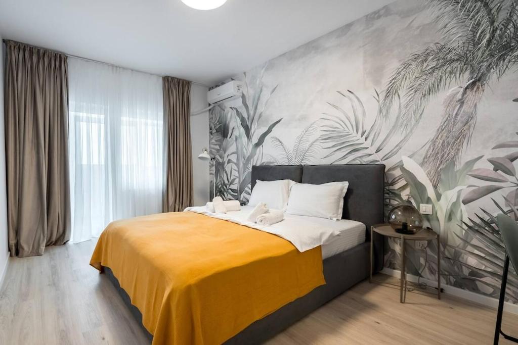a bedroom with a bed with a yellow blanket at Green Heaven Apartment 2106 - Underground Parking & Self Check-in in Bucharest