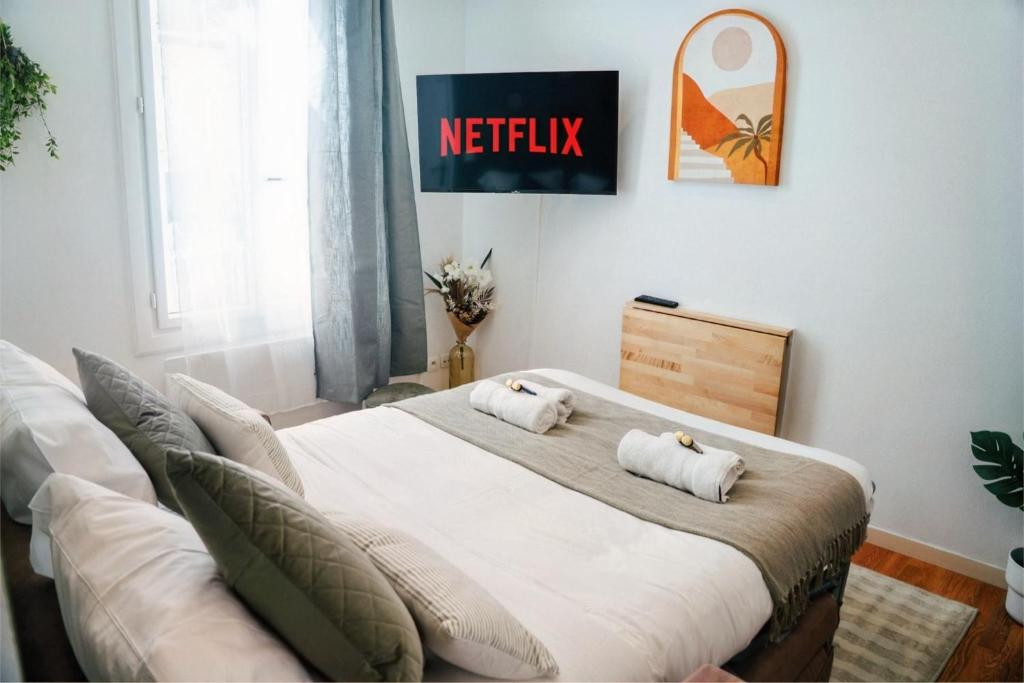 a bed with two pillows on it in a room at Le petit coin vert de Paris in Montreuil