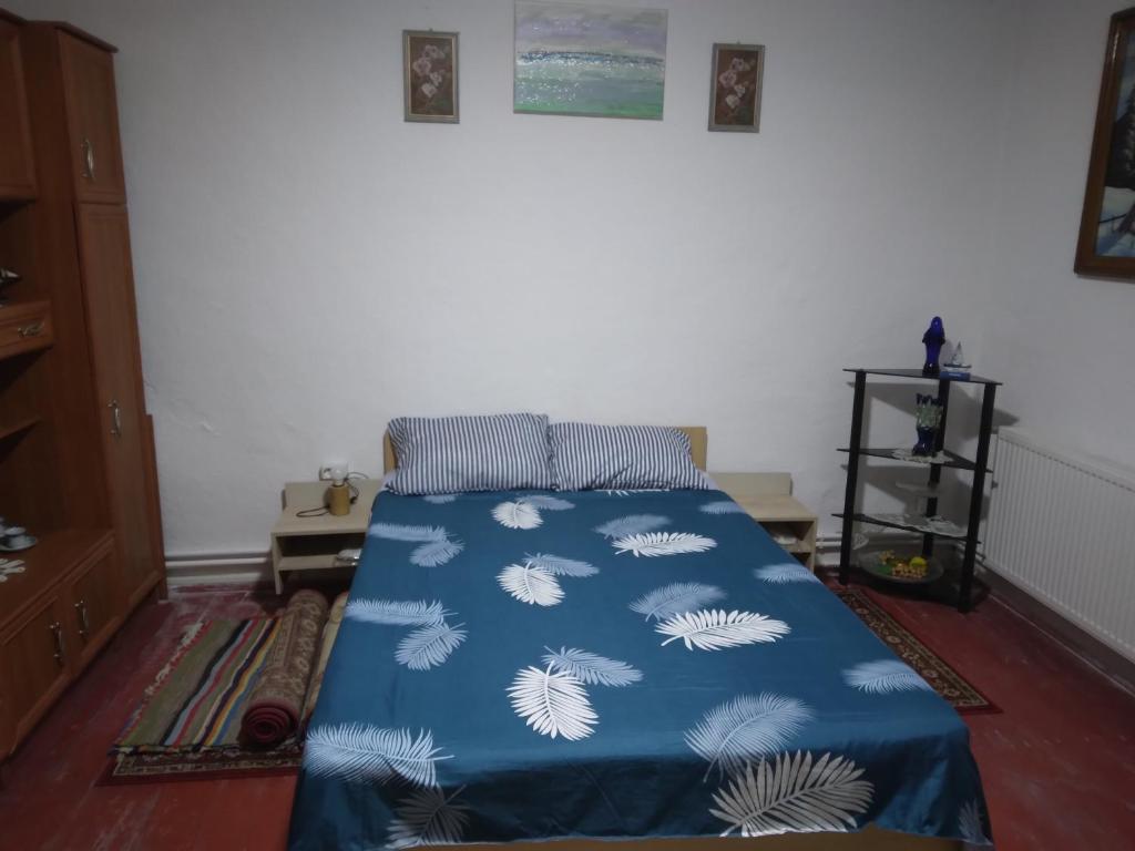 a bedroom with a bed with a blue blanket at Casa Antonyo in Jurilovca