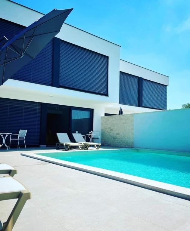 a swimming pool in front of a house at Melanie in Mazurija