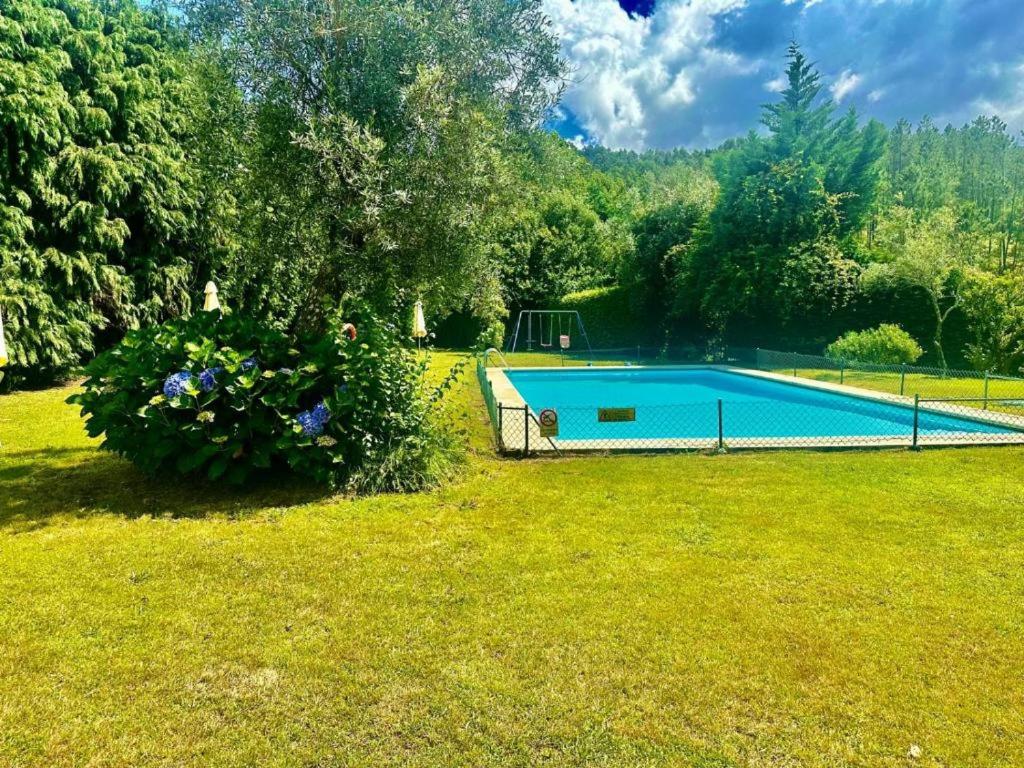 a swimming pool in the middle of a yard at Quinta do Pomarinho - by RowdHouses in Arouca