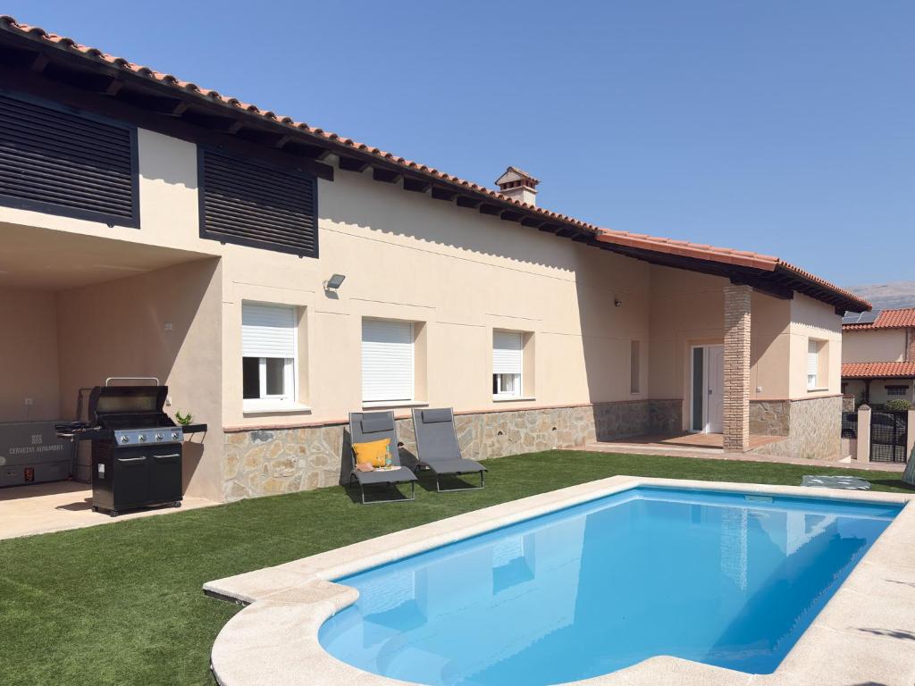 a swimming pool in a yard next to a house at TAYP OrigenHomes in Collado