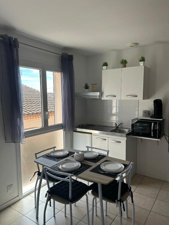 a kitchen with a table and two chairs and a table and a kitchen at Pont du Gard in Rodilhan