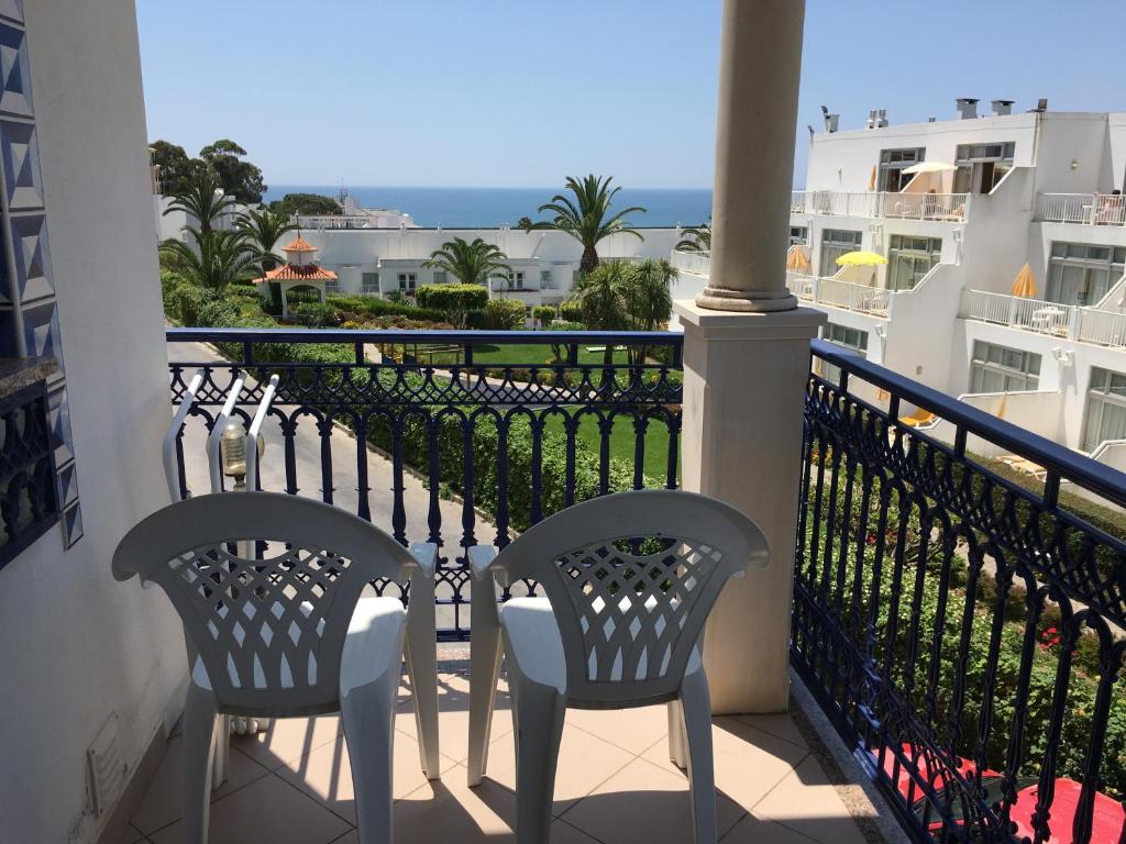two chairs on a balcony with a view of the ocean at Albufeira Bicos Beach Apartment in Albufeira