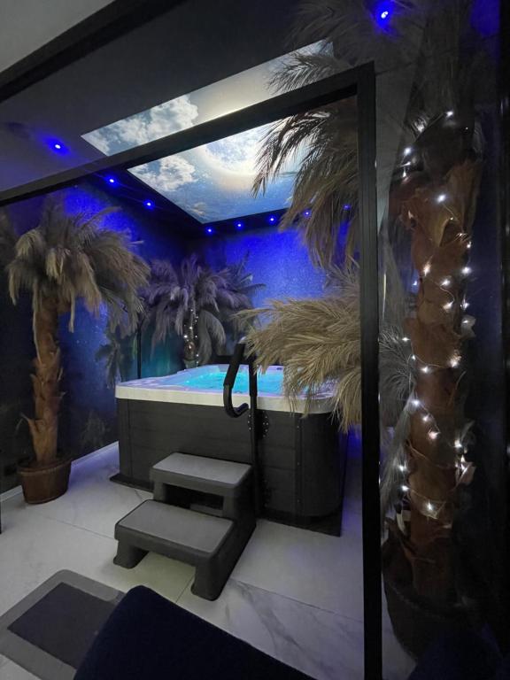 a bathroom with a spa tub with palm trees at Apartament Księżycowy z jacuzzi in Nowy Sącz