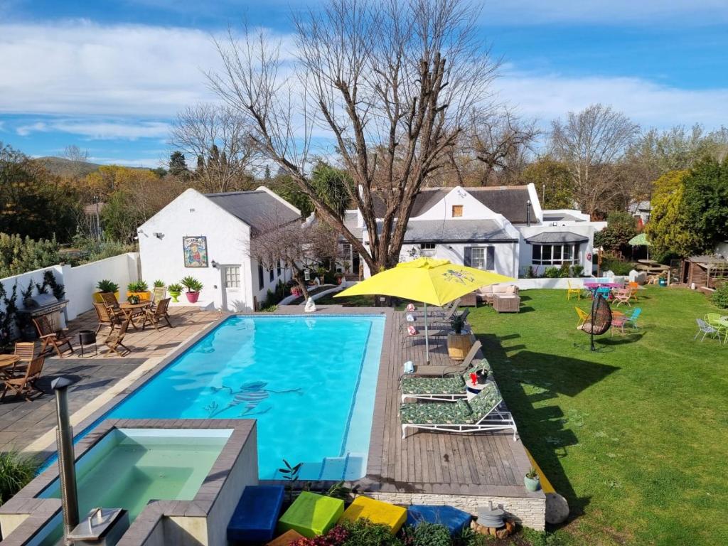 Un patio trasero con piscina y una casa. en Greyton Toad Hall Guesthouse - individual rooms, en Greyton