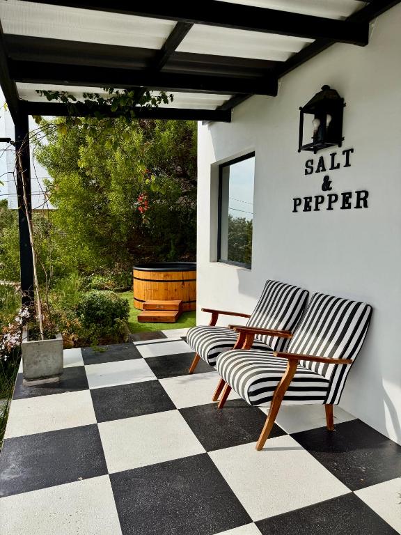a patio with two chairs and a table on a checkered floor at Salt & Pepper in Mossel Bay