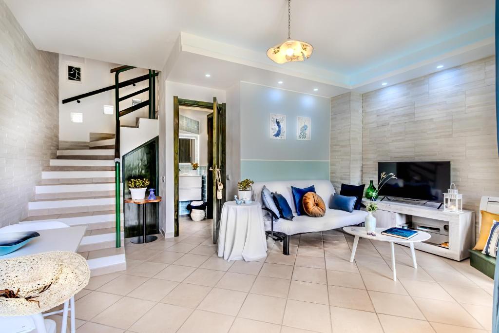 a living room with a couch and a staircase at Villino Le Pavoncelle in Torre delle Stelle