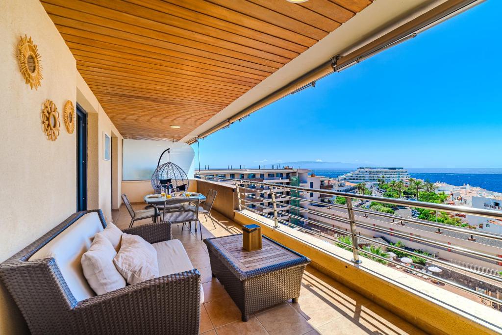 a balcony with a couch and chairs and a view at Hermitage Homes BLG in Puerto de Santiago