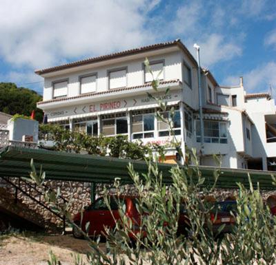 a large white building on top of a hill at Pensión El Pirineo in Confrides