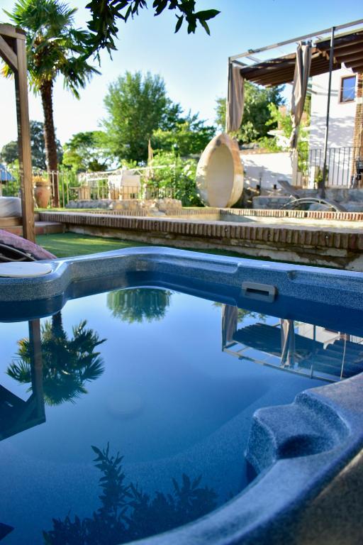 a swimming pool with blue water in a yard at Casa Rural Arados in Priego de Córdoba