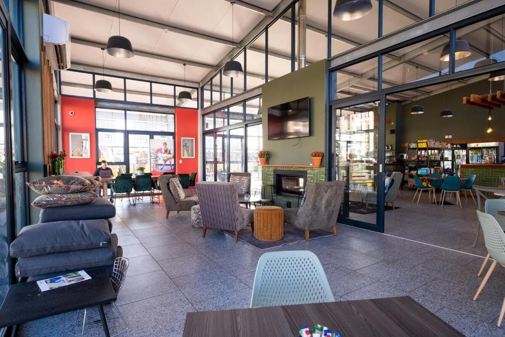 a lobby with chairs and tables and a fireplace at #AlimamaSpaces Manson's Fynbos Villa in Cape Town