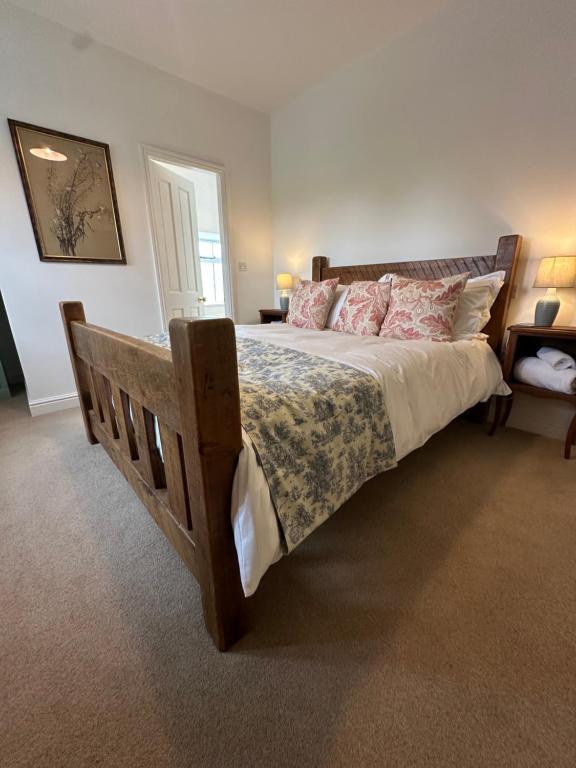 a bedroom with a large bed with a wooden frame at Overfield Farm in Ashbourne