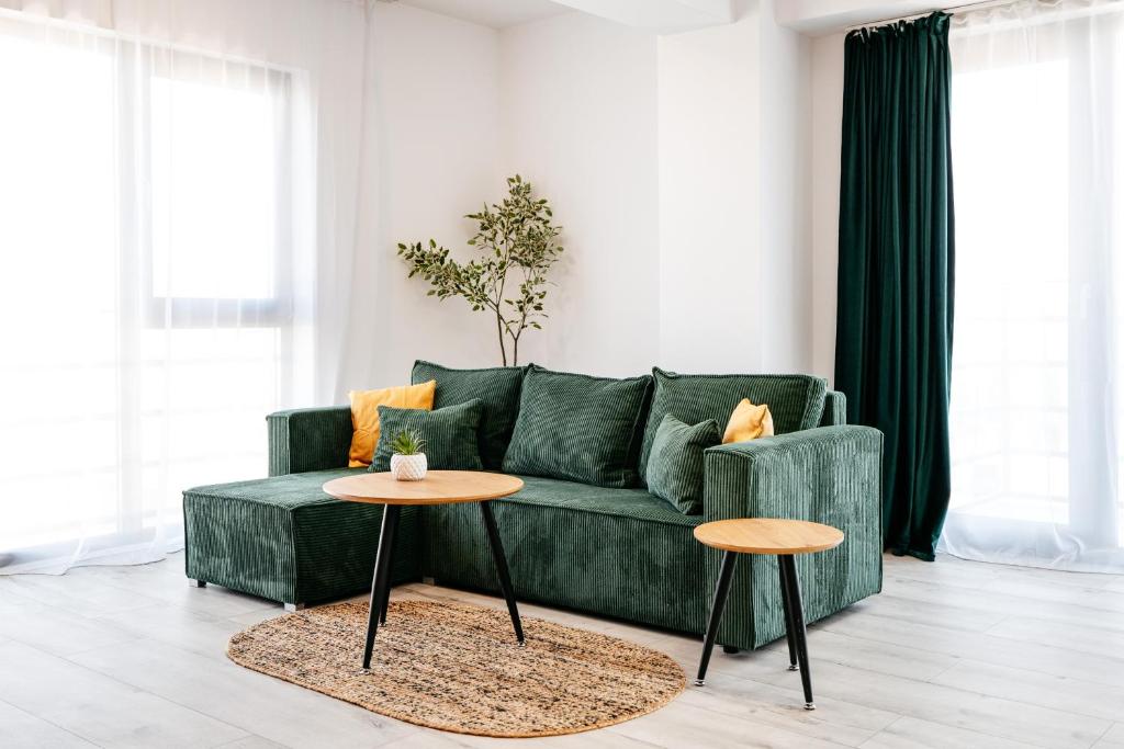 sala de estar con sofá verde y 2 mesas en Premium Tulip Apartments, en Tunarii