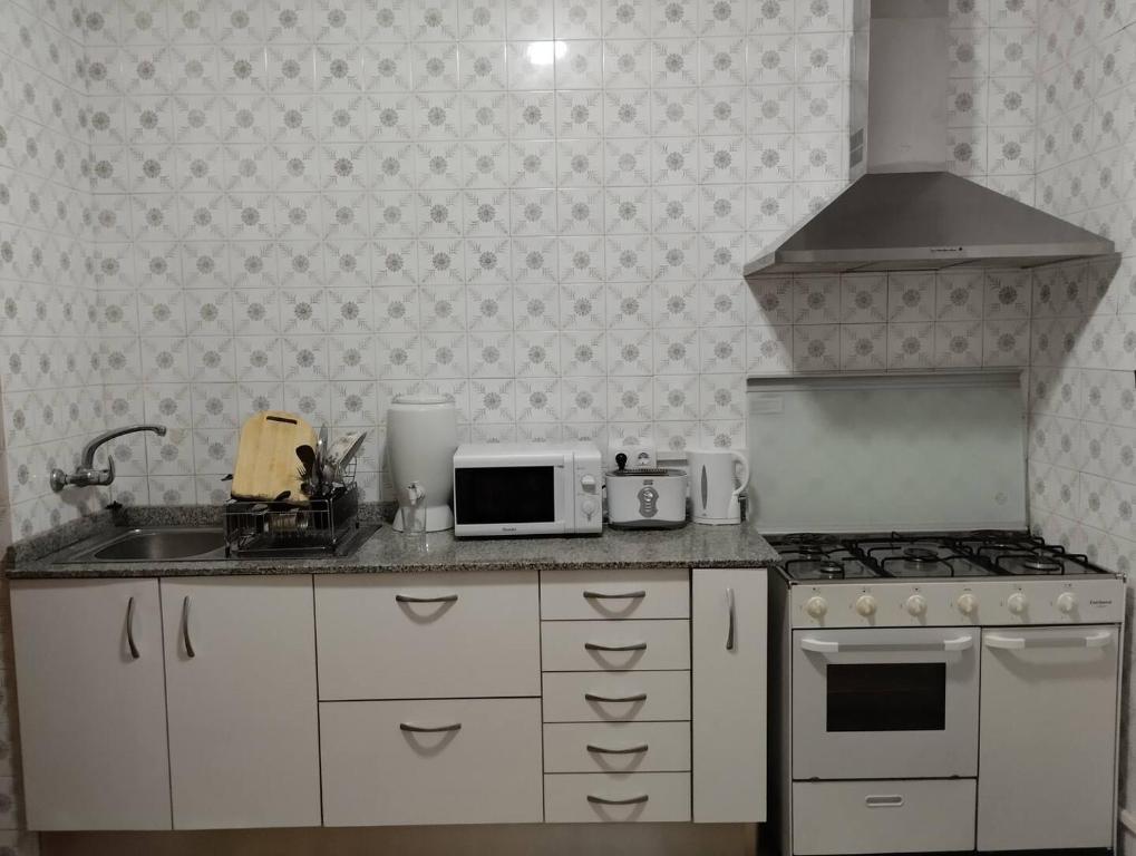 a kitchen with a stove and a microwave at Susa and Pepe garden and house in Agaete