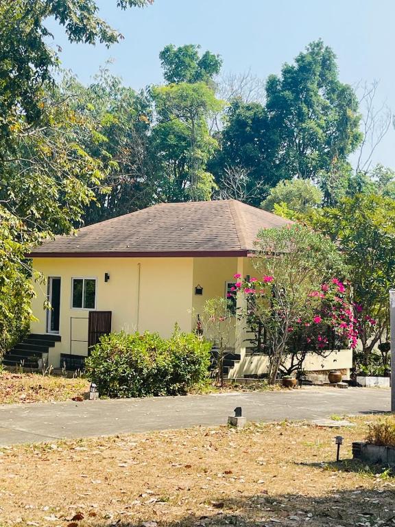 a yellow house with flowers in front of it at Jungle Breeze Bungalow, Fast WiFi, Quiet Retreat in Ban Dan Mai