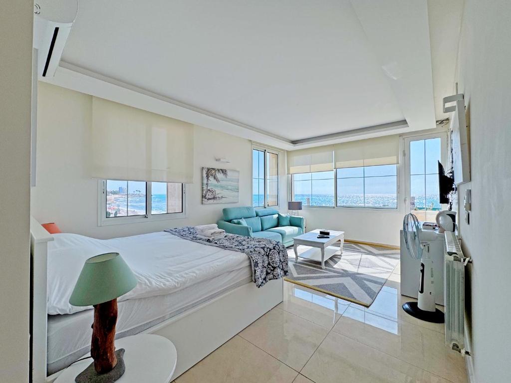 Un dormitorio con una cama grande y un sofá azul. en Halat sailing club Guest house, en Ad Dawwārah