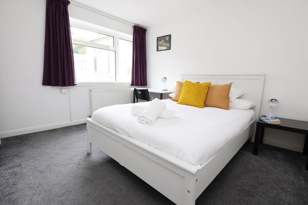 a bedroom with a white bed and a window at Ideal Bath House by St James’s Park in Bath