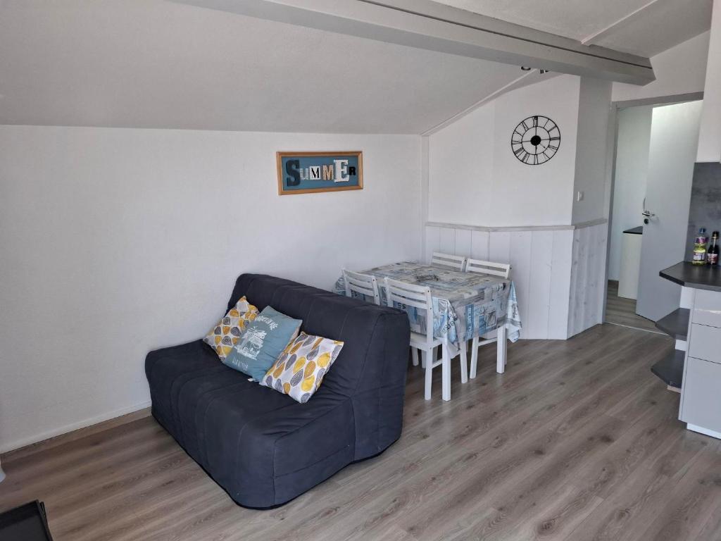un salon avec un canapé et une table dans l'établissement Appart Must1 Minimes avec Piscine, à La Rochelle