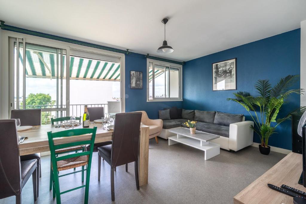 a living room with a couch and a dining room at La Belle Étape - Grand T5 à Cholet in Cholet