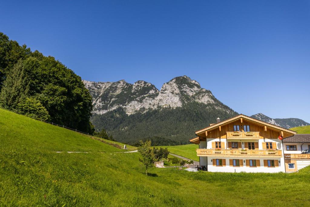 a house on a hill with mountains in the background at Lacklehen in Ramsau