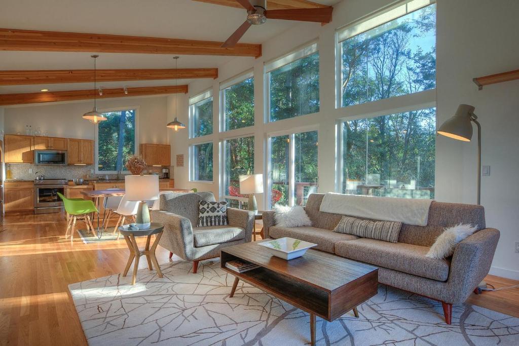 a living room with a couch and a table at Bright, Contemporary, Walk To Town & Beach in Eastsound