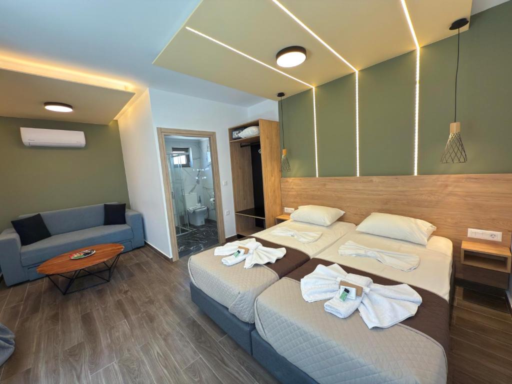 a hotel room with two beds and a couch at Elafonisi Paradise with Parking, WiFi, - Walking Distance to the Beach in Elafonisi