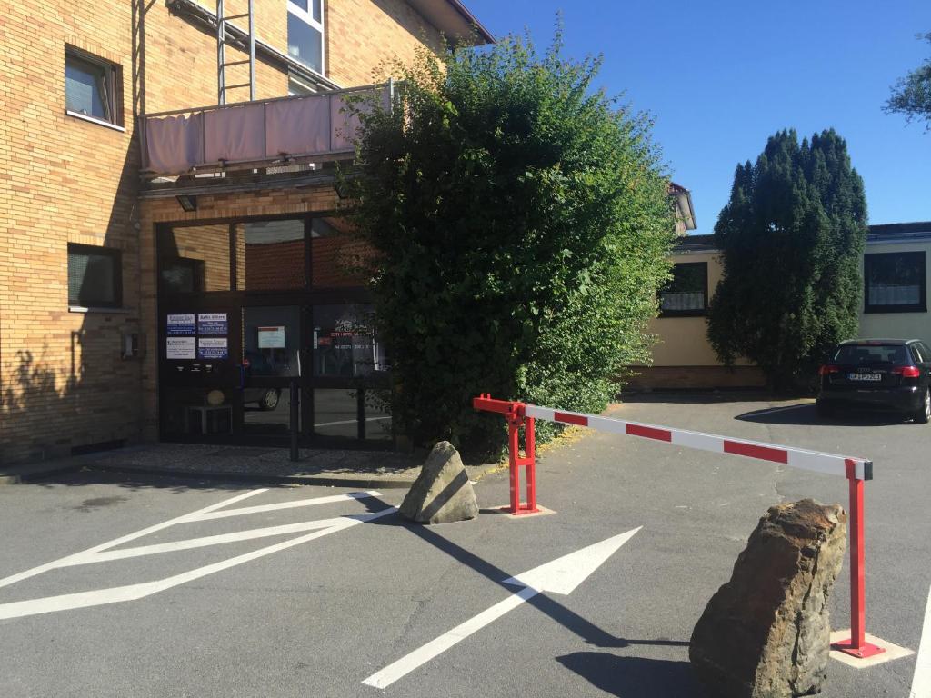 a parking lot with a caution tape in front of a building at City Hotel Gifhorn in Gifhorn