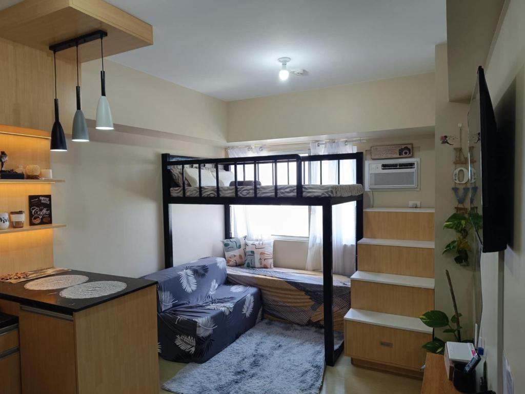 sala de estar con litera y cocina en The Comfort Pad Avida 2, en Cagayan de Oro