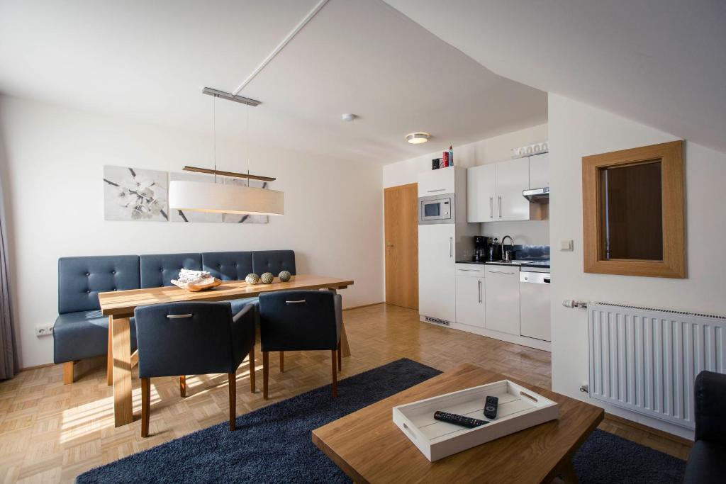 a kitchen and living room with a table and chairs at Alpenresidenz Turracher Höhe by ALPS RESORTS in Turracher Hohe