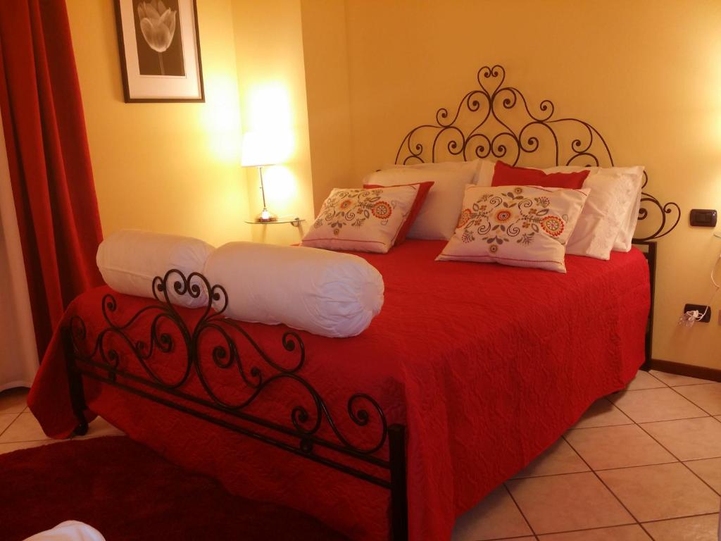 a bedroom with a red bed with white pillows at Peropero' in Gattinara