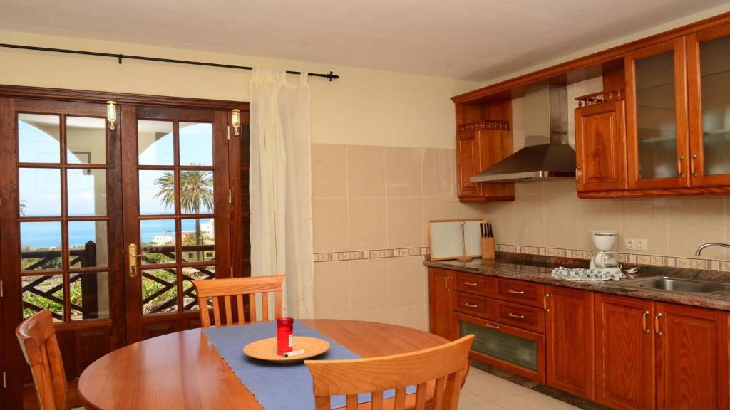 a kitchen with a wooden table and a dining room at Apt. Heliconia Nº 5 in La Playa Calera