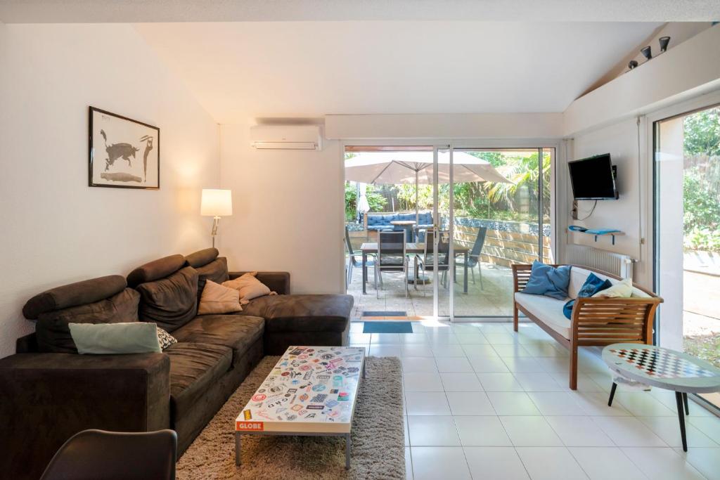 una sala de estar con un sofá y una mesa en Maison Chaleureuse Avec Terrasse, en Capbreton
