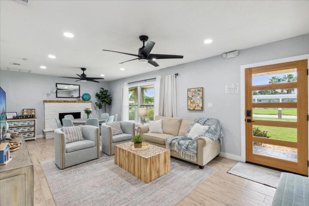 sala de estar con sofá, sillas y chimenea en 131 W Pasco Ln, en Cocoa Beach