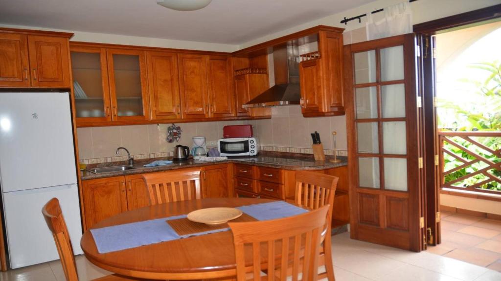 een keuken met een houten tafel en een witte koelkast bij Apartamento Heliconia 1 in Valle Gran Rey