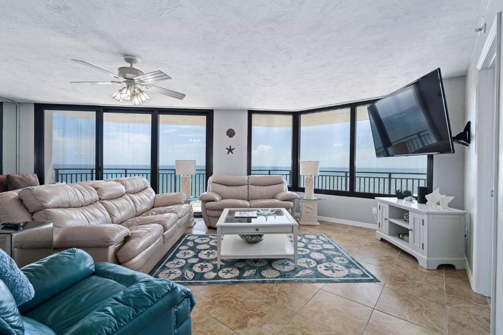 a living room with a couch and a flat screen tv at Beachfront 3 Bed, 3 Bath Condo, Balcony & Pool in Daytona Beach Shores