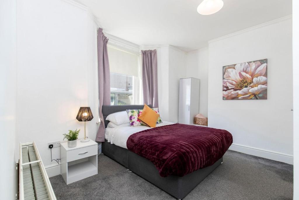 a bedroom with a bed with a purple comforter at 4 BEDS, 4 BATHS home, central Darlington in Darlington