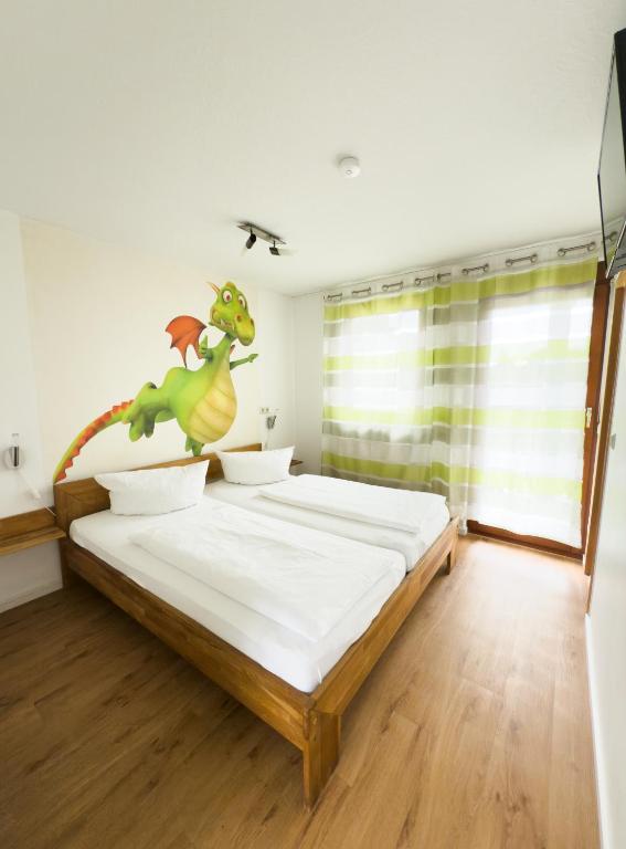 a bedroom with a bed with a dinosaur on the wall at Ruster Drachennest - Europa Park by living TIMELESS in Rust