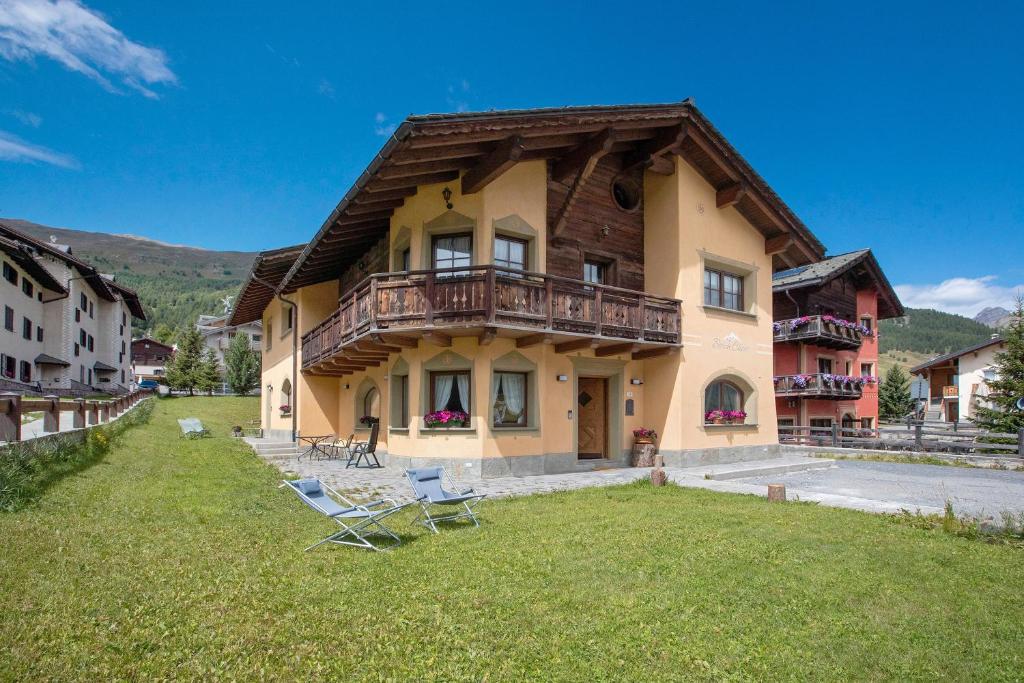 a house with a balcony and chairs in the yard at Borch Chalet Livigno in Livigno
