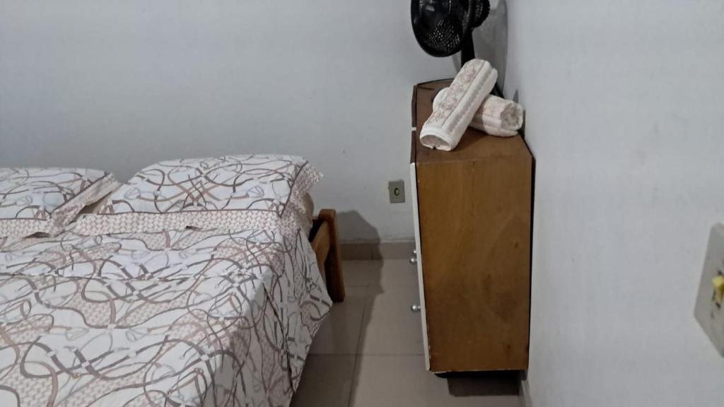 een slaapkamer met een bed en een dressoir met een telefoon erop bij Chalé Azul Aurora in Manhã