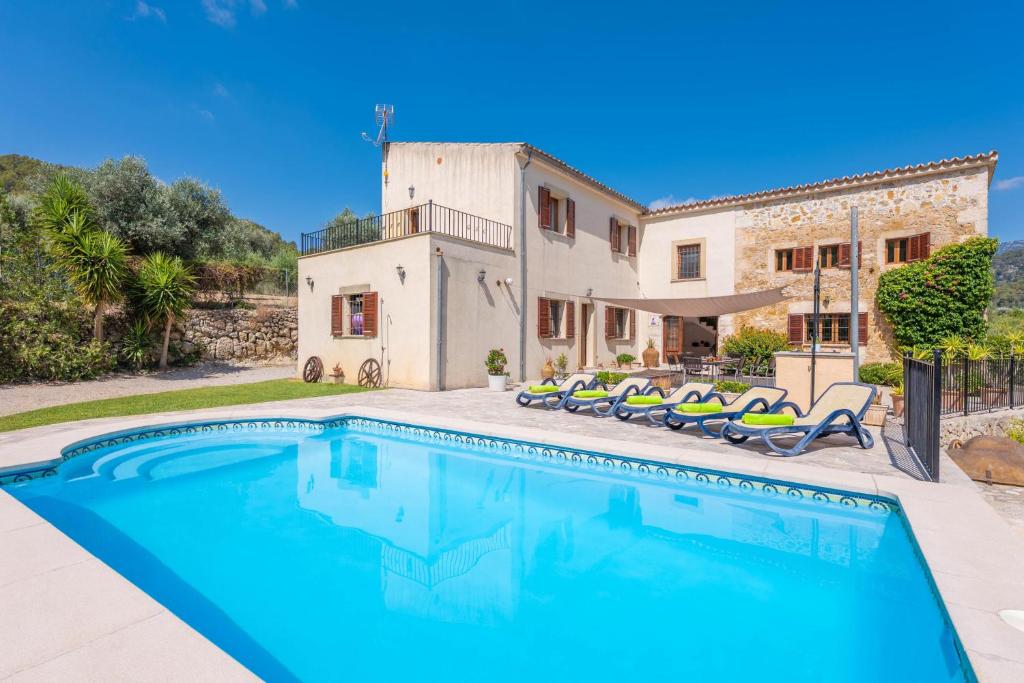 a villa with a swimming pool in front of a house at Sa Corterada in El Port de la Selva