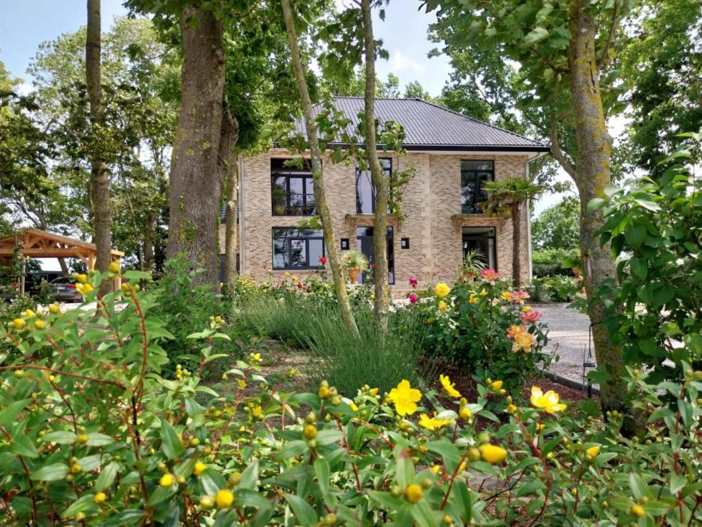 a garden with flowers in front of a house at Le Manoir in Guemps